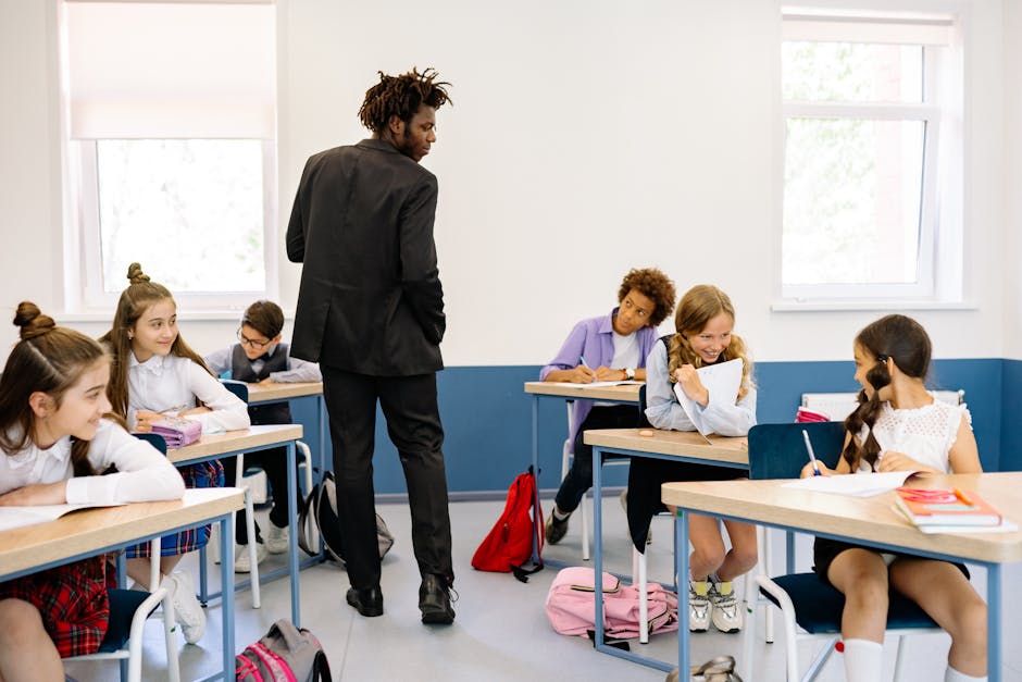 A teacher watches over students who are engaged in classroom activities on a bright day