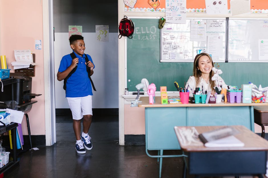 A cheerful student enters the classroom where a teacher is seated at a desk, ready for class